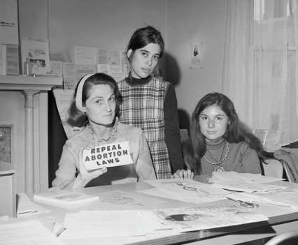 A leader in the movement for unrestricted abortion, Patricia Maginnis stands next to a bulletin board full of abortion information in Sausalito, Calif. in the 1960s.