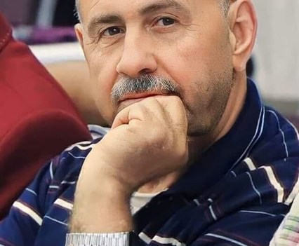 Abdelaziz Ashqar in a striped shirt, head thoughtfully resting on his hand.